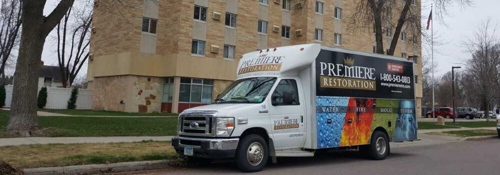 Premiere Restoration van in front of an apartment